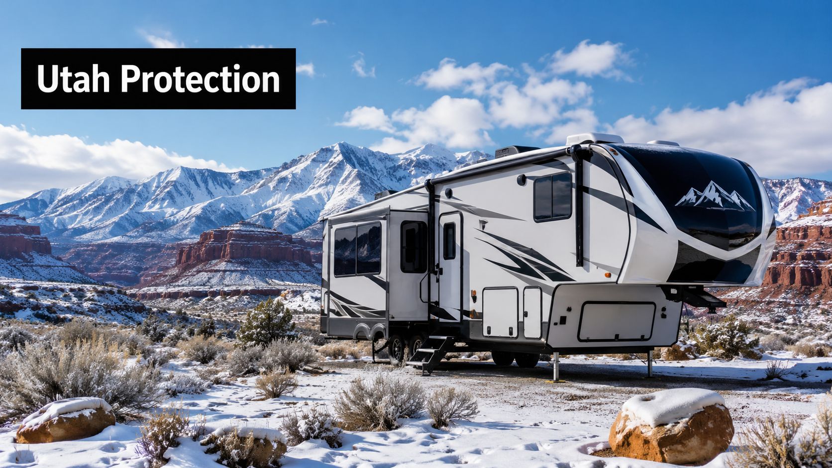 A modern fifth wheel camper parked in a scenic, snowy Utah desert landscape with majestic mountains behind.