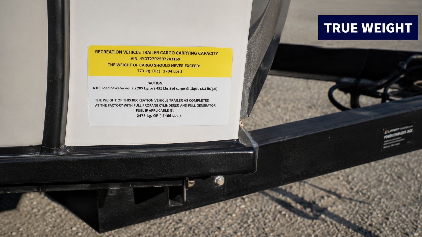 A close-up view of a vehicle information sticker on a travel trailer showing cargo weight capacity.
