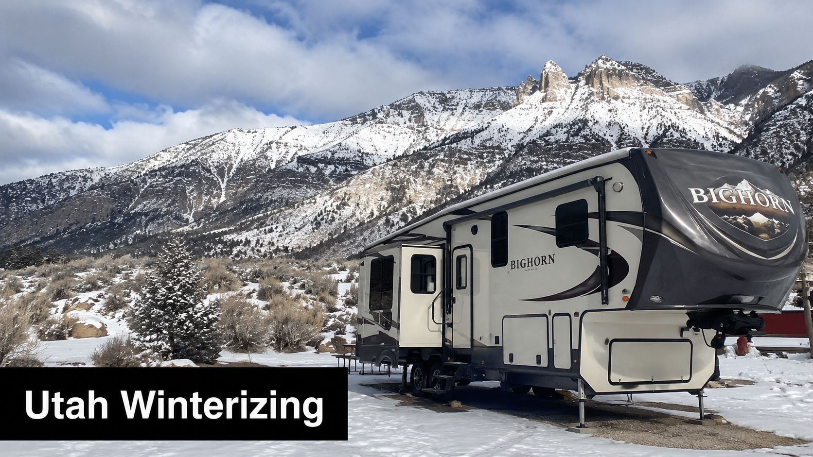 A large Bighorn fifth wheel RV parked in a snowy mountainous landscape during winter in Utah.