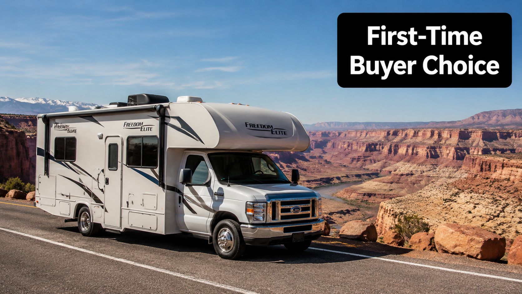 A white Freedom Elite Class C motorhome parked on a scenic road overlooking a desert canyon landscape.